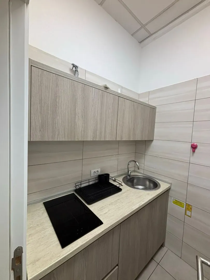 Small kitchen with cabinetry, built-in cooktop, and sink.
