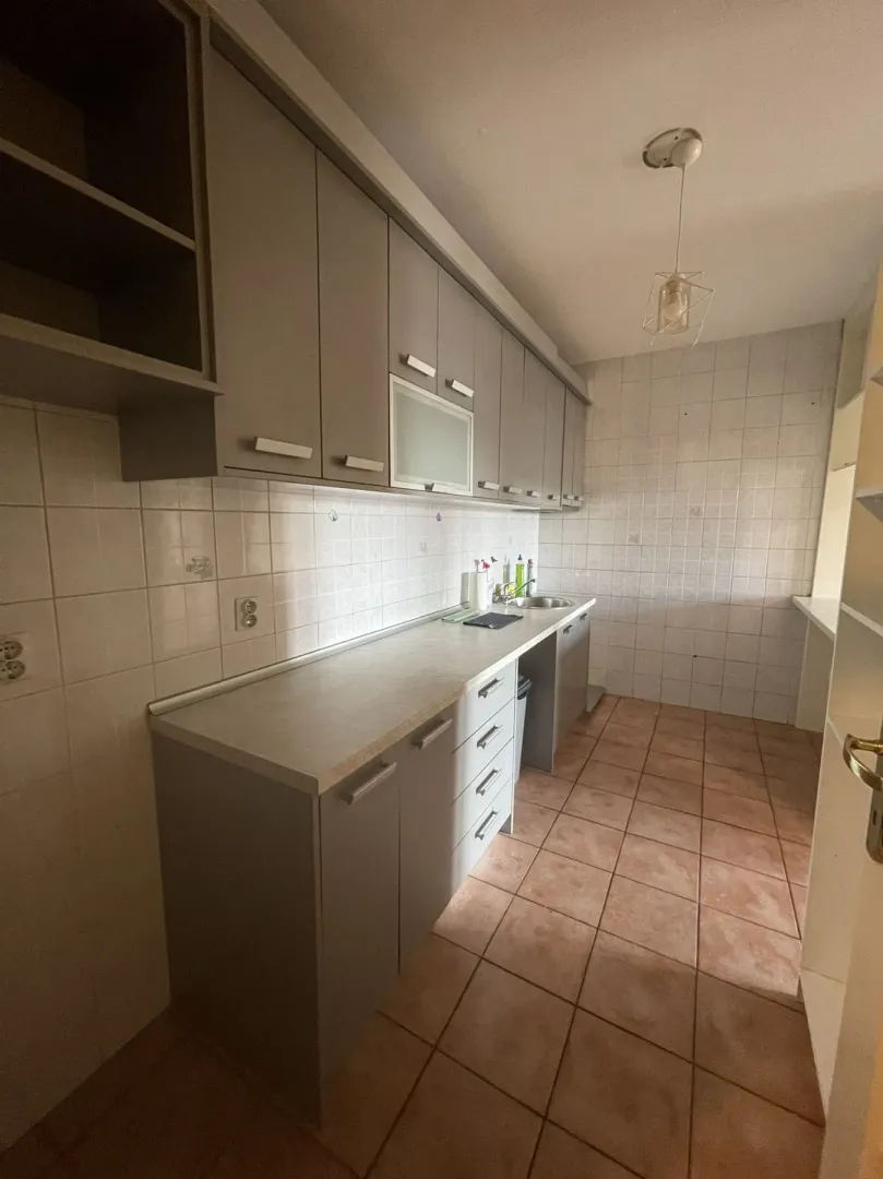 Simple kitchen with gray cabinets and floor tiles.