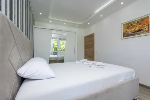 Bright bedroom with a large double bed, white wardrobe, and a painting on the wall. - image 5