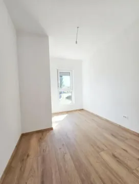 Prazna soba sa bijelim zidovima i drvenim podom. - image 4