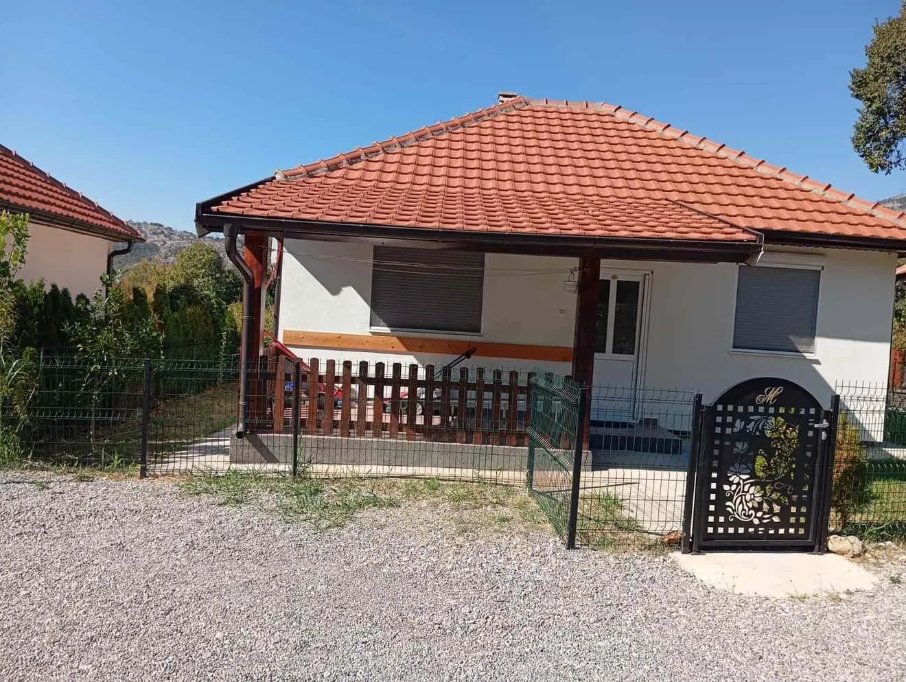 View of the exterior of the house with a yard and fence.