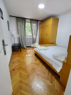Nameštena spavaća soba sa bračnim krevetom, drvenim ormarom i parketom. - image 4