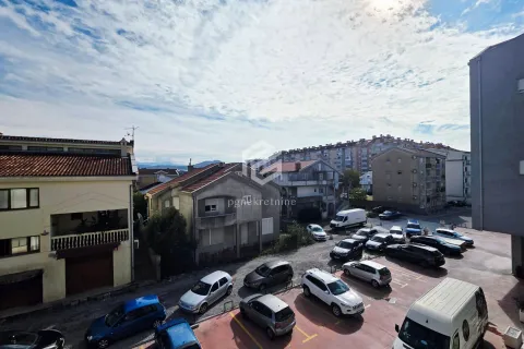 View from the window overlooking surrounding buildings and parking. - image 14
