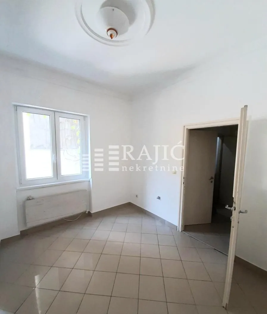 Empty room with tiled flooring and a window.