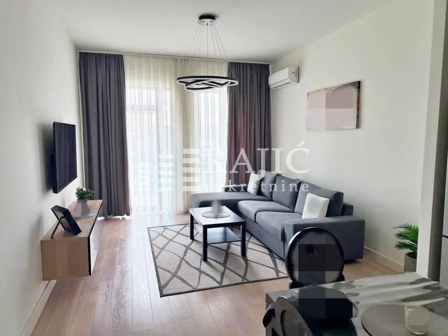 Living room with a sofa, TV, and dining table.