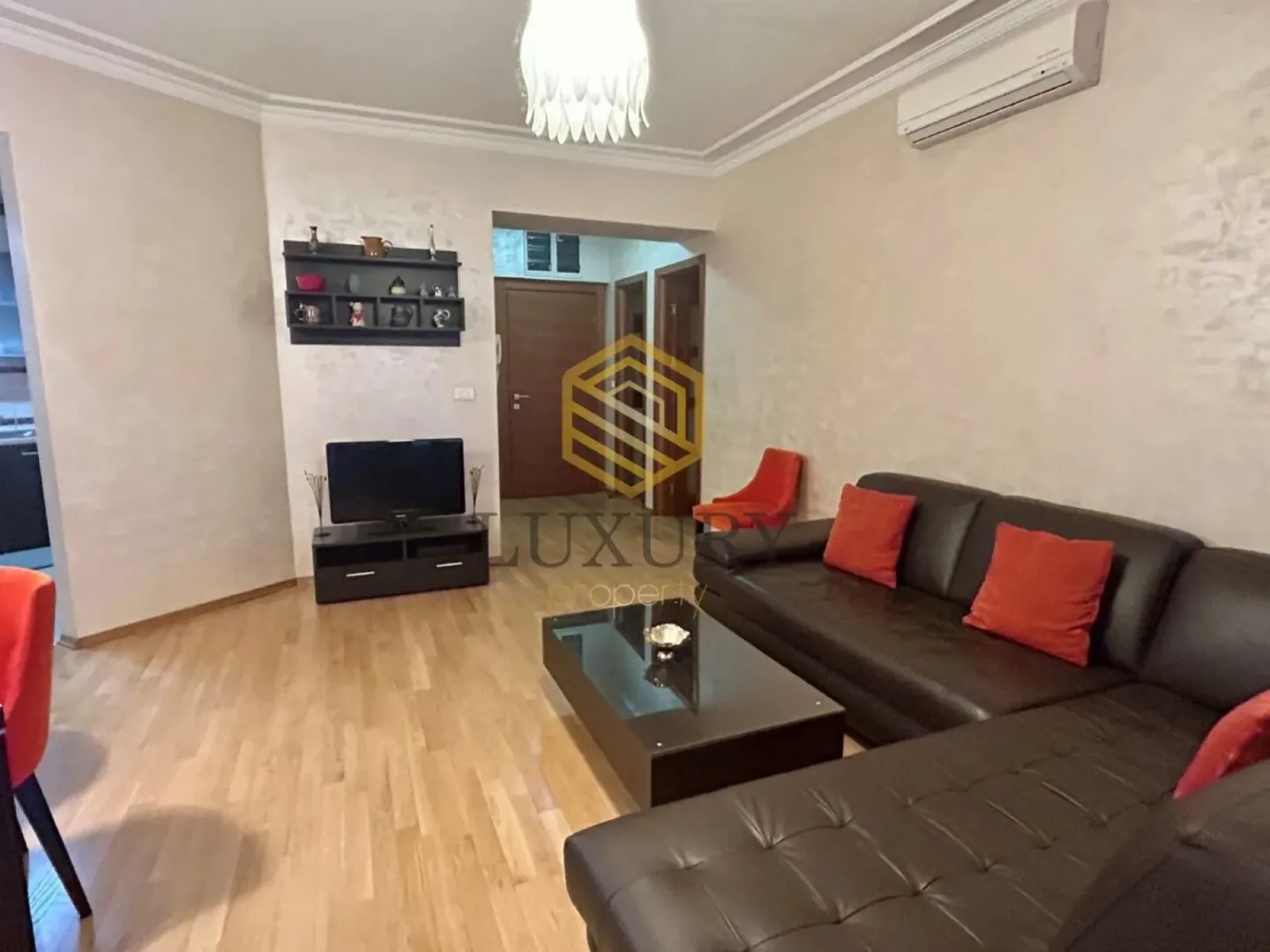 Dnevna soba sa garniturom, stočićem i TV-om.