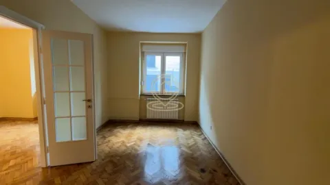 Prazna soba sa parketom i vratima koja vode u hodnik. - image 12