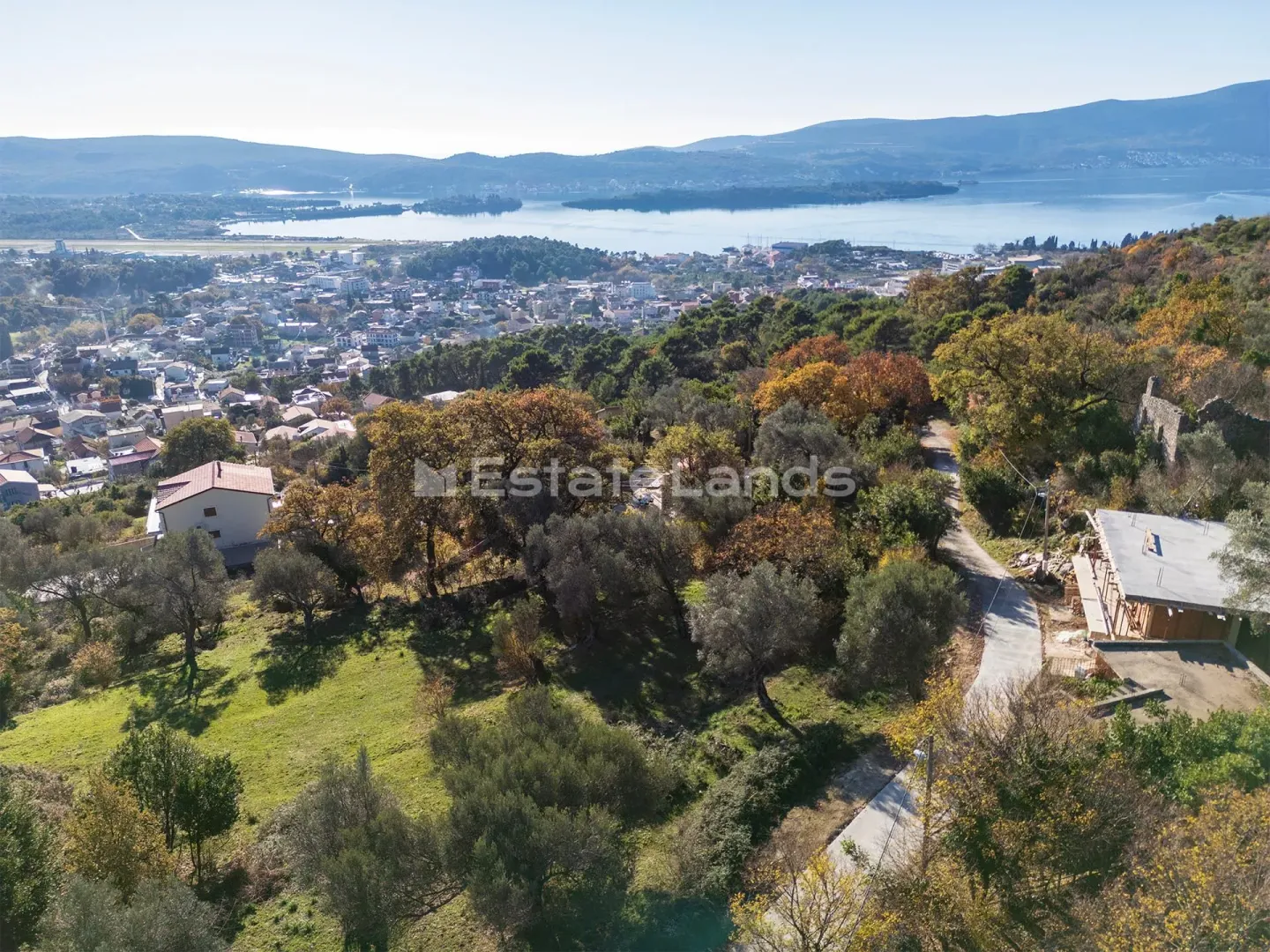 Pogled iz vazduha na zemljište sa zelenilom i okolnim pejzažem.