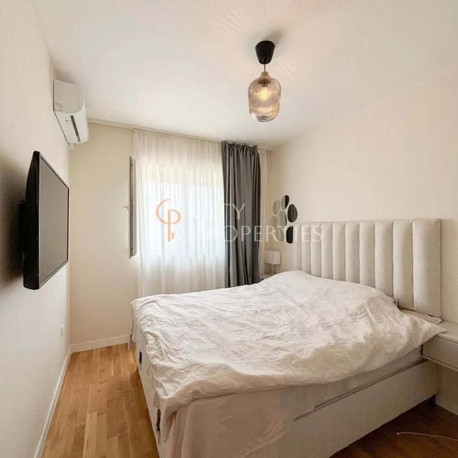 Furnished bedroom with a double bed, TV, and air conditioning.