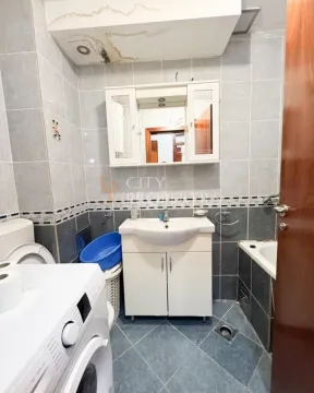 Bathroom equipped with a sink, cabinet, bathtub, and washing machine. - image 9