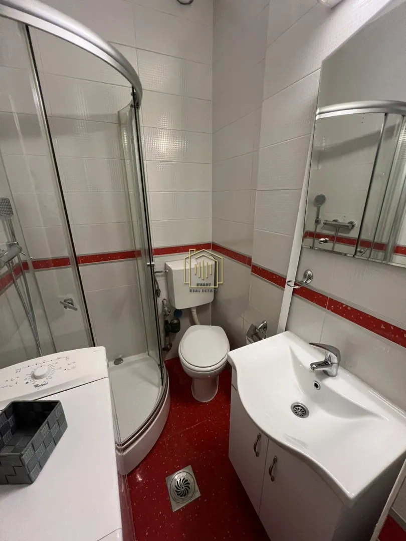Manje kupatilo sa tuš kabinom, umivaonikom i wc šoljom.