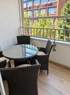 Natkriveni balkon sa stolom i pletenim stolicama za sedenje. - image 13