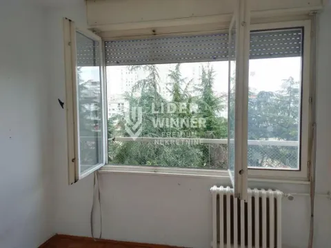 Empty room with an open window and a view of trees. - image 18