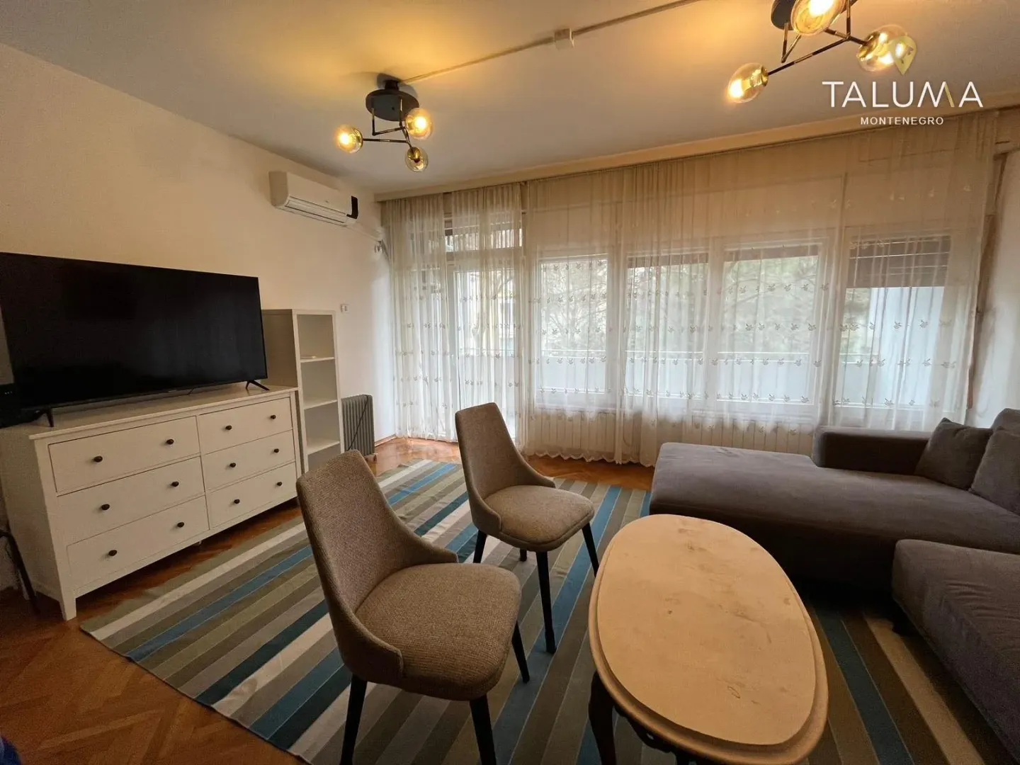 Living room with a sofa set, television, and dining table with chairs.