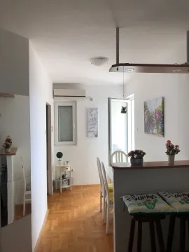 Small kitchen with a dining area and wooden flooring. - image 7