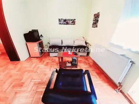 Manja dnevna soba sa garniturom za sedenje i parketom na podu. - image 7