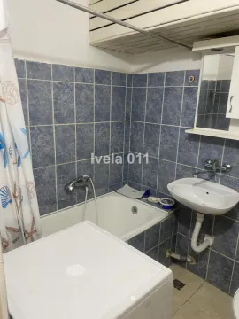 Small bathroom with a bathtub, sink, and blue wall tiles. - image 6