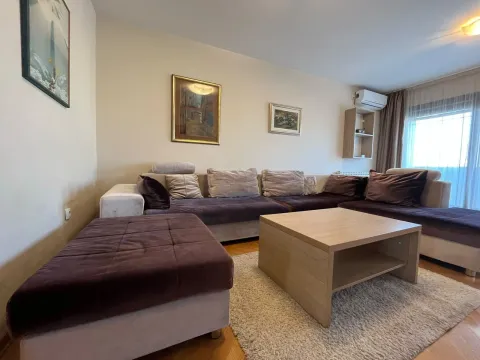 Dnevna soba sa ugaonom garniturom, stočićem i slikama na zidu. - image 3