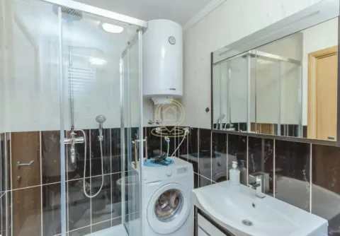 Bathroom equipped with a shower cabin, washbasin, washing machine, and water heater. - image 5