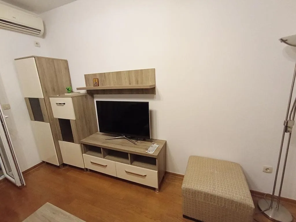 Dnevni boravak sa TV komodom i klima uređajem.