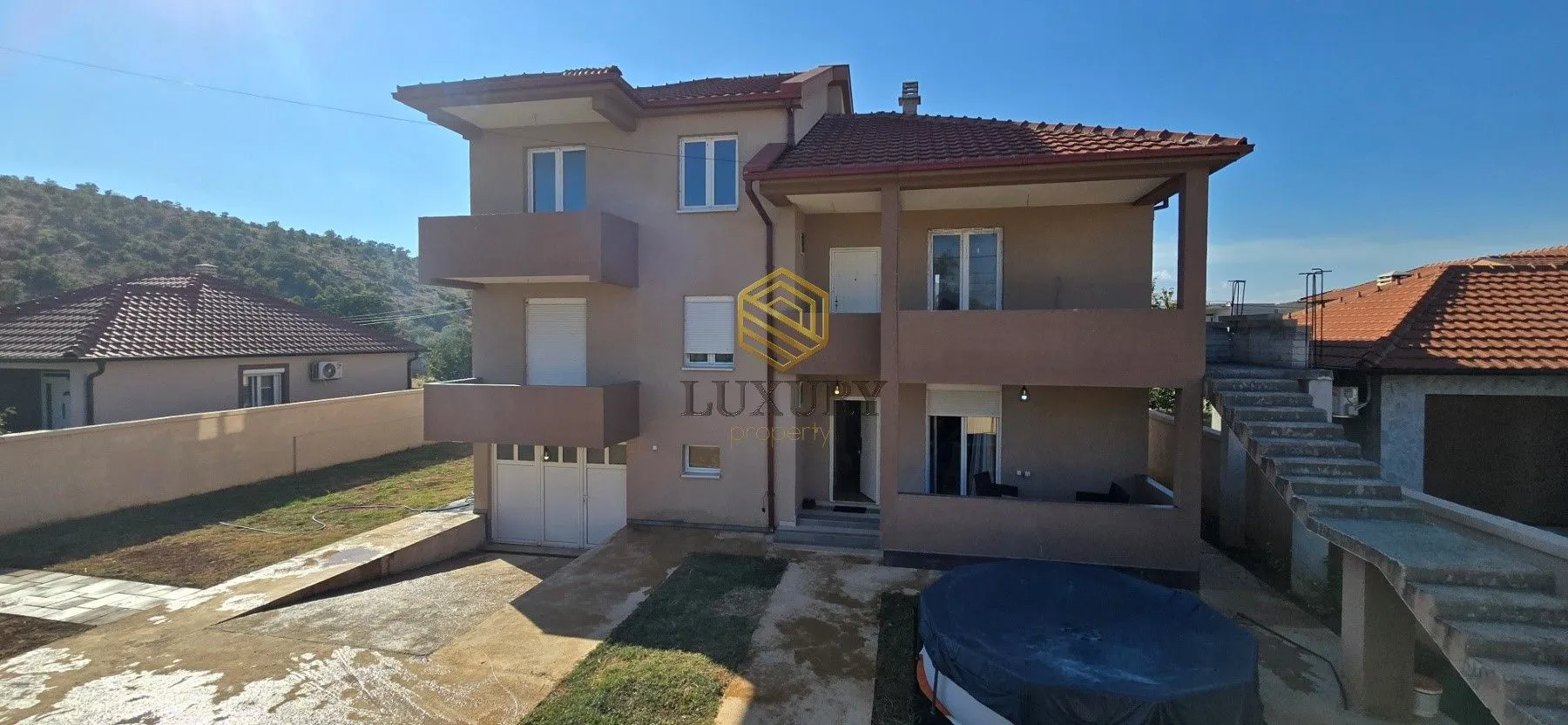 Exterior of a multi-family house with a yard and external stairs.