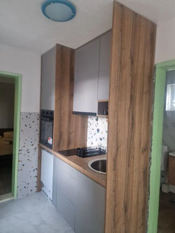 Small kitchen with wooden cabinets and a built-in sink.