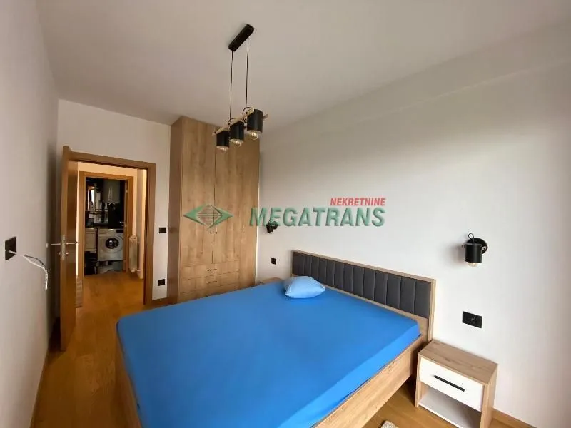 Furnished bedroom with a double bed, wardrobe, and a nightstand.