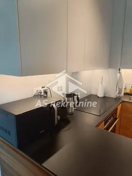 Pogled na dio moderne kuhinje sa radnom površinom i aparatima. - image 11