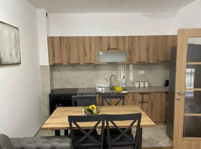 Kitchen with wooden cabinetry and a dining table with chairs.