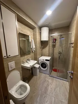Kupatilo opremljeno tuš kabinom, umivaonikom, WC šoljom i mašinom za veš. - image 6