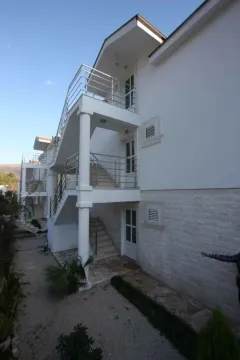 Pogled na spoljašnjost zgrade sa stepeništem i balkonima. - image 2