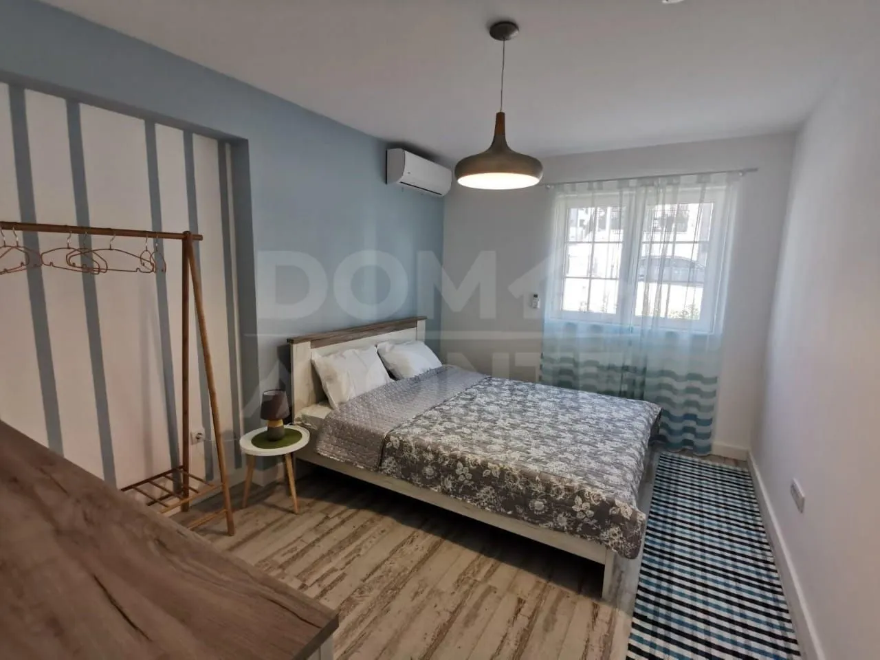 Decorated bedroom with a double bed and a window.