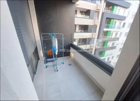Small tiled balcony with a glass railing and a laundry drying rack. - image 19