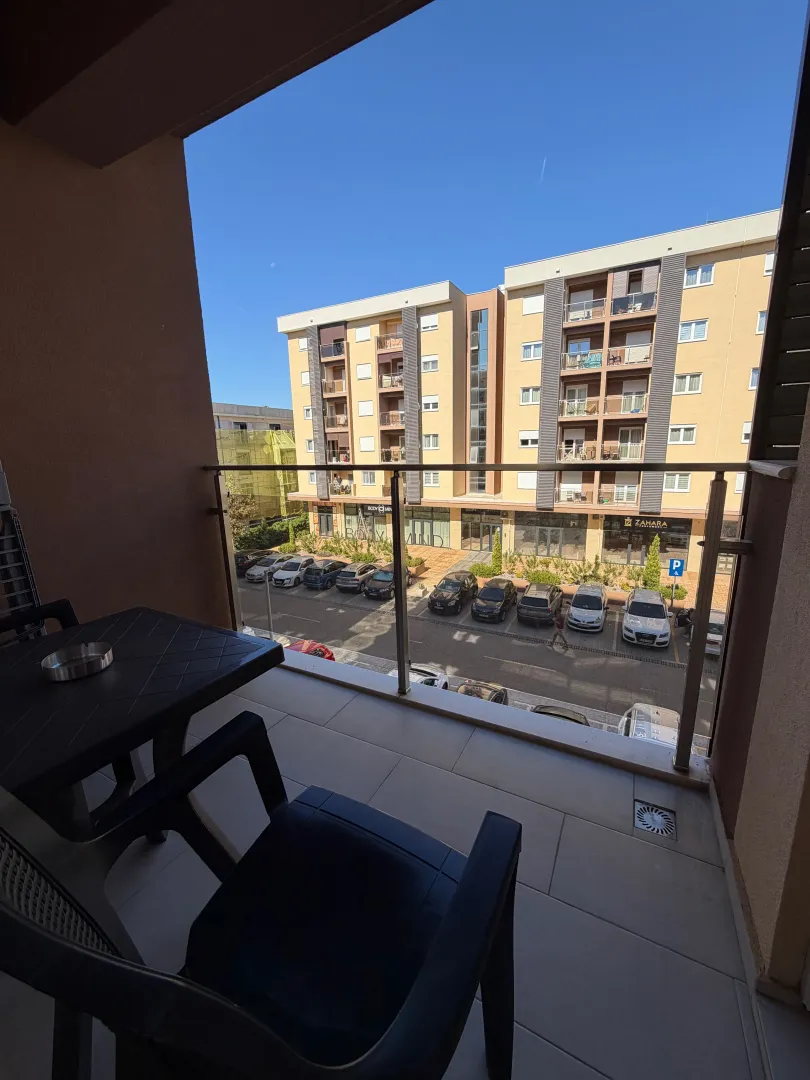 View from the balcony overlooking buildings and the parking lot in front.