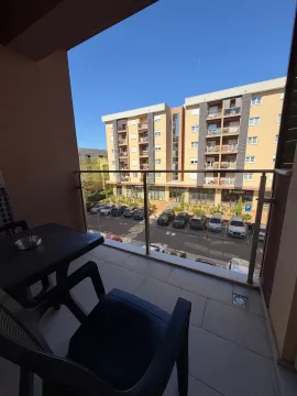 View from the balcony overlooking buildings and the parking lot in front. - image 9