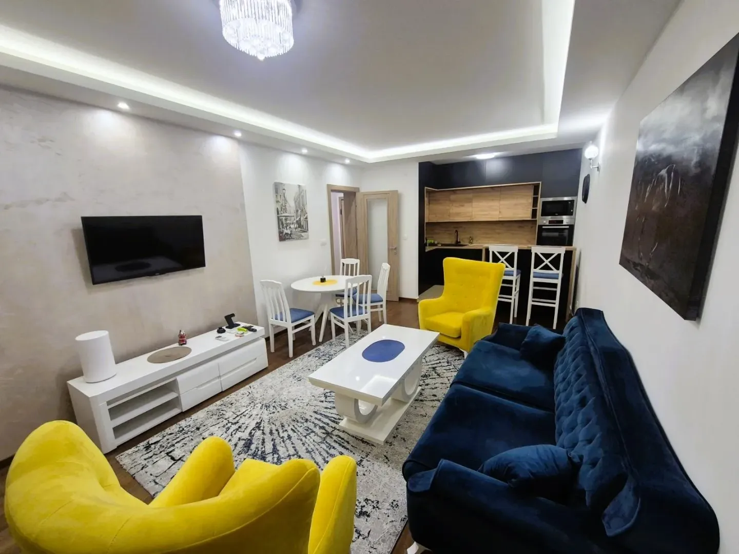 Living room with sofa set, dining area, and open kitchen.