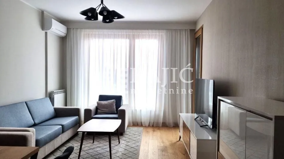 Living room with a sofa, TV, and dining table.