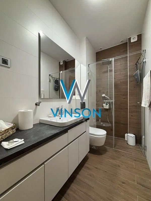 Modern bathroom with walk-in shower, washbasin, and built-in vanity units.