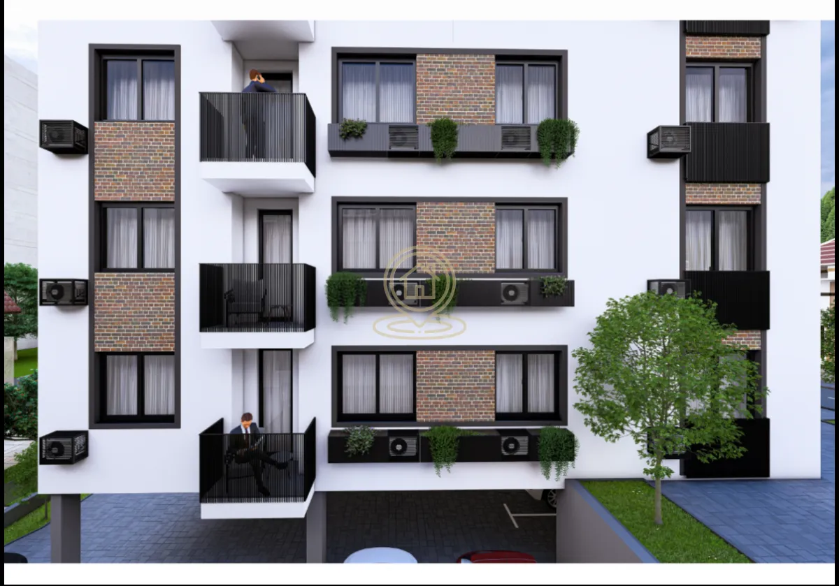 Spoljašnji izgled moderne stambene zgrade sa balkonom i uređenim dvorištem.