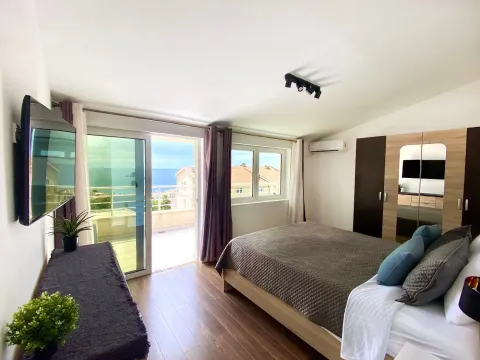 Bright bedroom with a double bed, wardrobe, and access to a terrace with a sea view. - image 9