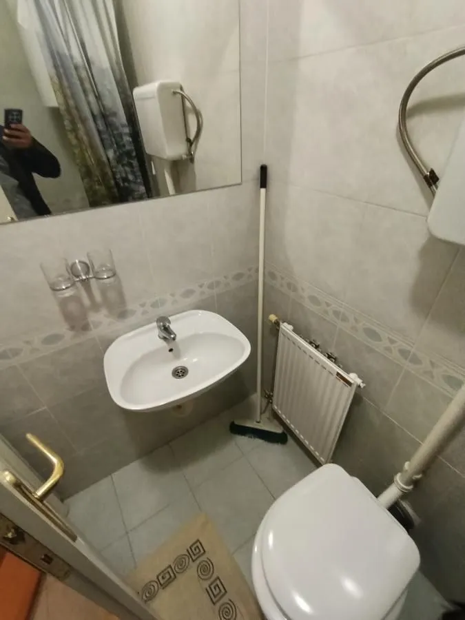 Manje kupatilo sa umivaonikom, WC šoljom i ogledalom.