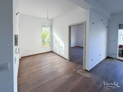 Prazna prostorija sa drvenim podom, bijelim zidovima i prozorom. - image 3