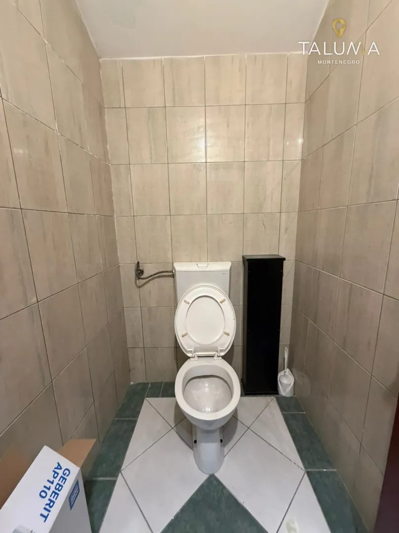 Smaller tiled bathroom with a toilet.