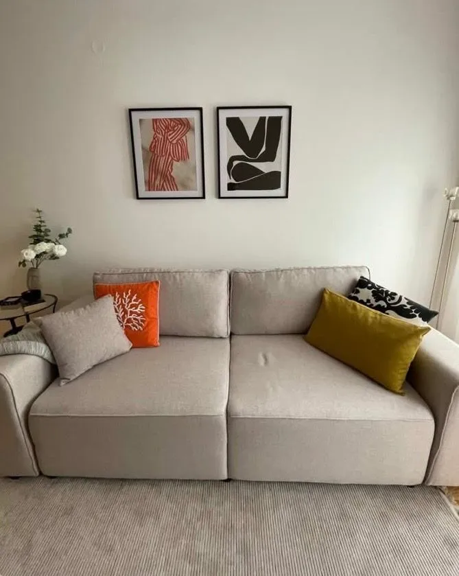 Living room with a comfortable beige sofa and decorative pillows.