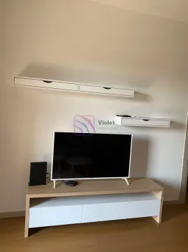 Living room with a television and mounted white wall shelves. - image 7