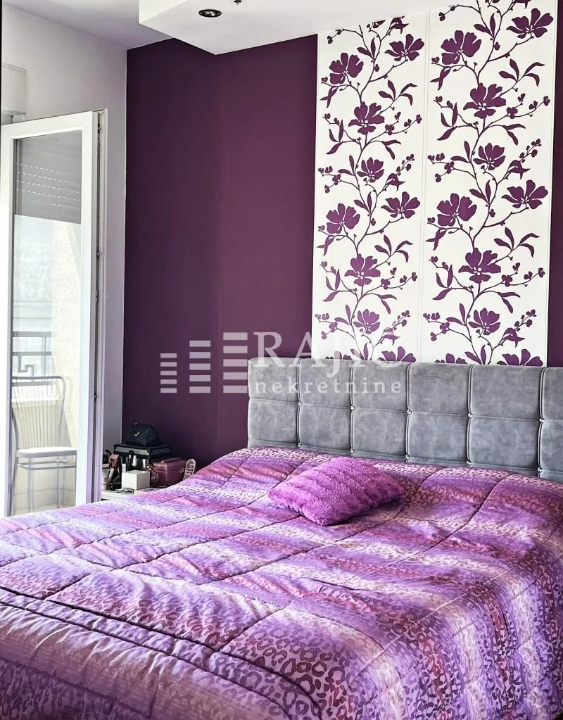 Furnished bedroom with a double bed and purple details.