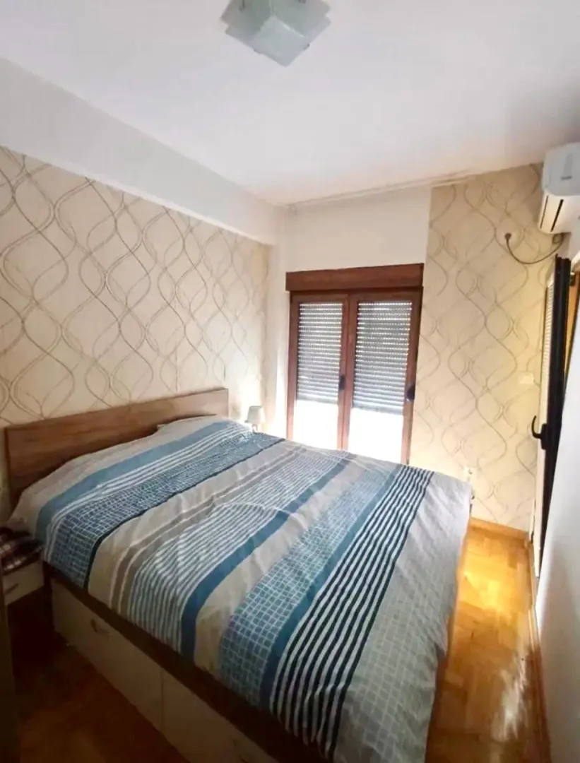 Namještena spavaća soba sa bračnim krevetom.