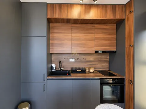 Modern kitchen with dark cabinetry and wooden accents. - image 6