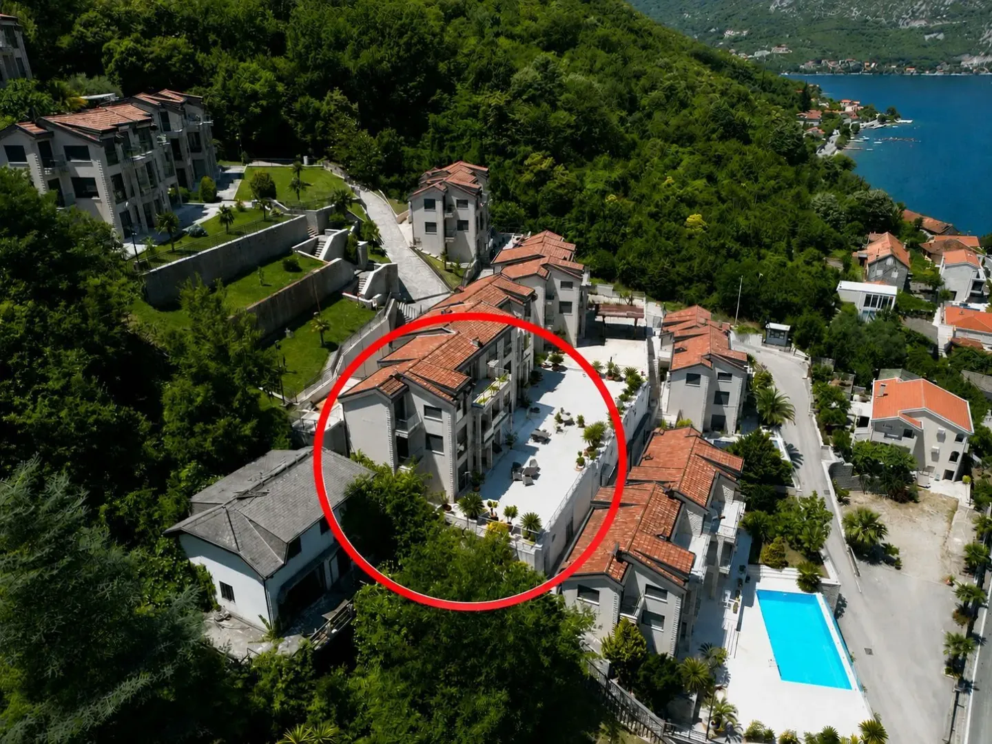 Pogled iz vazduha na stambeni kompleks sa bazenom u blizini mora.