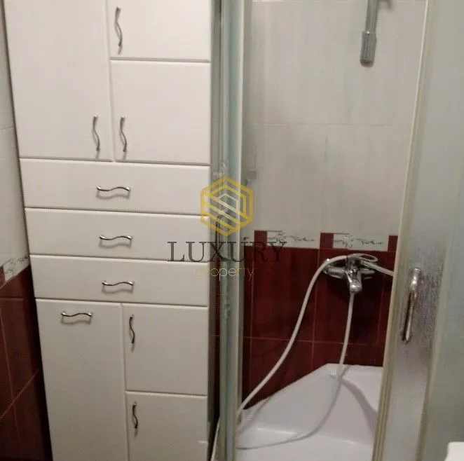 Kompaktno kupatilo sa bijelim elementima i tuš kabinom.
